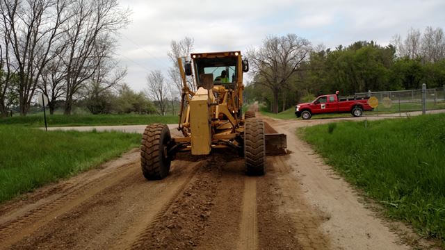 Surface grading being performed along the road.